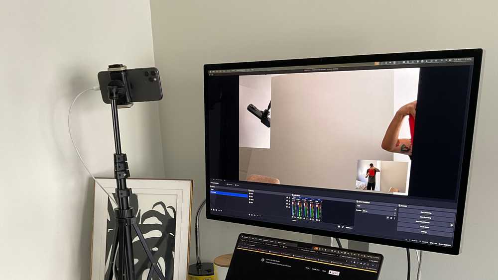 An iPhone mounted as a camera and connected by USB to a computer running OBS Studio.